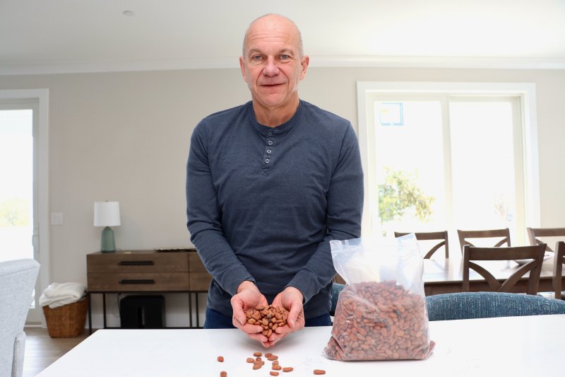 Tim Ahn in the kitchen of his Lewes home holding raw cocoa beans from Mexico. Ahn is one of the world’s leading experts on cocoa beans and chocolate. He is a quality assurance professional who inspects a wide variety of food and pet food plants to make sure products are safe.
BILL SHULL PHOTO